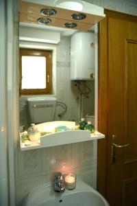 un baño con lavabo y espejo en Apartmani Boss, en Vrnjačka Banja 24 fotos más