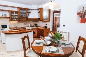 kuchnia z drewnianym stołem z krzesłami i jadalnią w obiekcie Apartma Barbara w Koprze