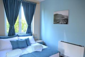 a blue bedroom with a bed with blue curtains at Open Doors Bed & Breakfast in Shkodër