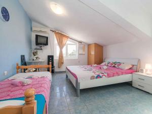 a bedroom with two beds and a television in it at Maki Apartments - Plavi Horizonti Beach in Tivat