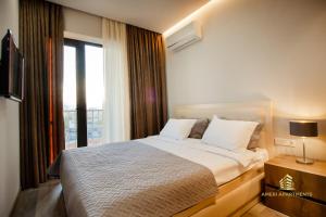 a bedroom with a bed and a large window at Ameri Apartments Tbilisi in Tbilisi City