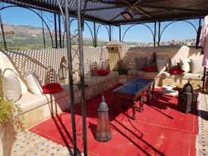 a group of couches and tables under an umbrella at Riad Fes Kettani in Fez