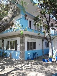 une maison bleue et blanche avec un arbre dans l'établissement Island Apartments, à Nea Vrasna