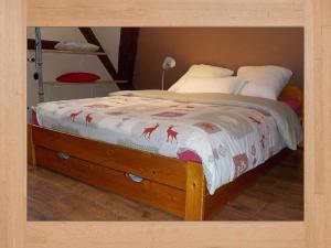 ein Schlafzimmer mit einem Bett mit einem Bettrahmen aus Holz in der Unterkunft La Pouponiere in Sainte-Marie-aux-Mines