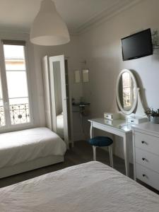 a bedroom with a bed and a desk and a mirror at Le Jardin Darcy Liberté Hyper centre gare-ville parking public payant dans la rue in Dijon