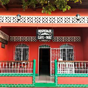 Hospedaje y Cafe Ruiz في غرناطة: مبنى احمر مع لافته مكتوب داخل كافيه مي