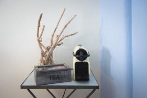 a table with a clock and a plant on it at JUST BLUE with amazing Sea Views in Piso Livadi in Piso Livadi