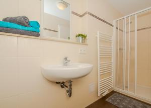 a white bathroom with a sink and a shower at Spreewaldapartments-Kossatz in Lübben +115 photos