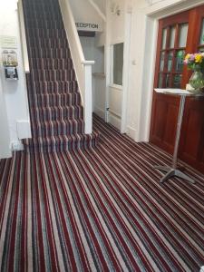 a hallway with a red and white striped carpet at Barton Hotel in Blackpool