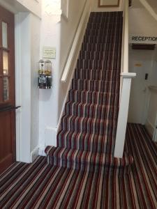 a staircase in a house with a striped carpet at Barton Hotel in Blackpool