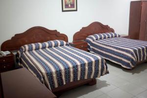 two beds sitting next to each other in a room at Hotel Latino in Panama City