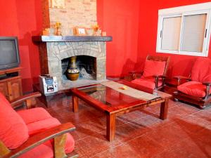 a living room with red walls and a fireplace at Chalet para 9 personas in Monte Hermoso