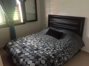 a bedroom with a bed with a black pillow and a window at Appartement B-23 Cabo Négro in Cabo Negro