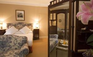 una camera con letto, divano e specchio di Posada Real Casa de Tepa ad Astorga