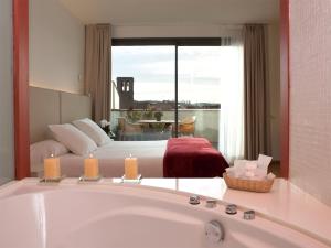 een badkamer met een bed en een bad in een kamer bij Hotel Balneario Prats in Caldes de Malavella