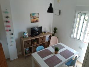 a dining room with a white table and a television at Appartement Lago Jardin in Torrevieja