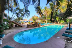 a beach with a pool, chairs, and a pool table at Hotel Santa Fe in Puerto Escondido
