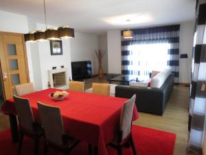 uma sala de estar com uma mesa vermelha e cadeiras em Relax & Sea View Apartment na Nazaré