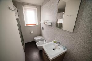 a bathroom with a white sink and a toilet at Casa Nicole in Castelbuono +48 photos