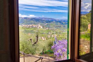 a window with a view of a town and flowers at Casa Mara - Diano Serreta in Diano Marina