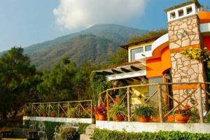 um edifício com vasos de plantas em frente a uma montanha em Santa María del Lago em San Pedro La Laguna