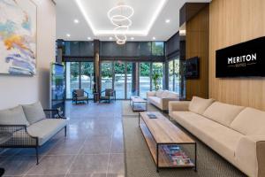 a living room with a couch and a table at Meriton Suites Waterloo in Sydney