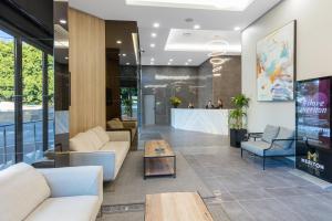 a lobby with couches and tables and a bar at Meriton Suites Waterloo in Sydney