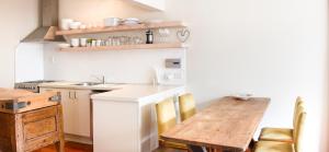 a kitchen with a wooden table and a table and chairs at The Snug in Hastings