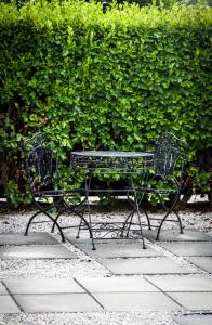 two black benches sitting in front of a hedge at The Snug in Hastings