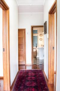 a hallway with a red rug on the floor at The Snug in Hastings