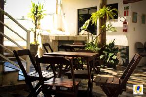 a wooden table and chairs on a patio with plants at Pousada Santa Maria in Aparecida