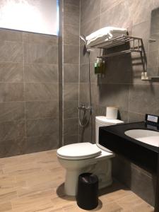 a bathroom with a toilet and a sink at Kenting Peninsula Inn in Kenting +37 photos