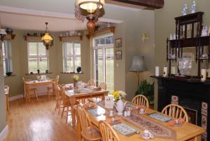 uma sala de jantar com mesas e cadeiras de madeira em Kilburn House B&B em Milltown