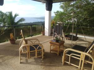 a patio with two chairs and a table with a view at Seaview Mansion Dalaguete Apartment 3 in Dalaguete