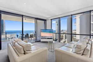 a living room with white furniture and large windows at Holiday Holiday Circle On Cavill Apartments in Gold Coast