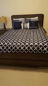 a bed with a black and white comforter at 2 BEDROOM / 1 BATH ONLY 9 MILES TO NAVY BASE in Sinajana