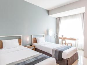 Postel nebo postele na pokoji v ubytování Hug Nimman Hotel