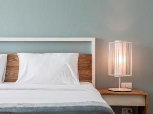 Postel nebo postele na pokoji v ubytování Hug Nimman Hotel
