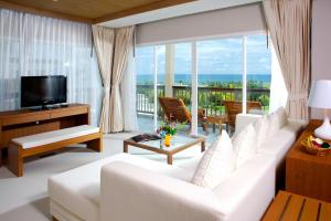 a living room with a white couch and a large window at Princess Seaview Resort & Spa - SHA Plus in Karon Beach