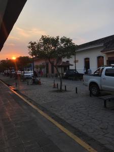 a truck parked on a street with the sunset in the background at Hospedaje y Cafe Ruiz in Granada