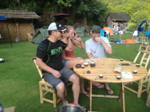 a group of people sitting around a wooden table at Zhangjiajie Jijiehao Inn in Zhangjiajie