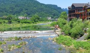 a river with a building in the middle of a town at Zhangjiajie Jijiehao Inn in Zhangjiajie