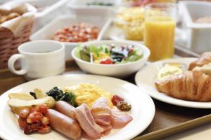 a table with plates of breakfast foods and drinks at Kisarazu Washington Hotel in Kisarazu