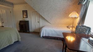 a bedroom with a bed and a table and a chair at The Bissell House Bed & Breakfast in Pasadena