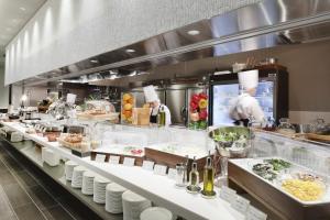 una cocina con dos chefs que preparan comida en un restaurante en Kisarazu Washington Hotel, en Kisarazu