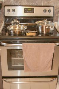 a stove with two pots and a towel on it at 2 BEDROOM / 1 BATH ONLY 5 MINUTES AWAY FROM BANK OF HAWAII in Sinajana