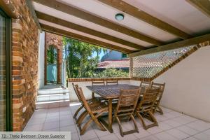 a patio with a table and chairs on a balcony at The Terraces Main Beach in Byron Bay
