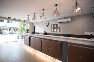 a kitchen with a long counter and pendant lights at Ipoh Sakura Hotel in Ipoh
