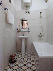 a white bathroom with a sink and a tub and a sink at Khách sạn Đồng Dao in Hue