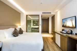 Postel nebo postele na pokoji v ubytování Comodo Nha Trang Hotel